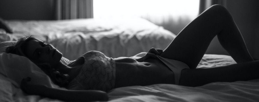 une femme couchée sur un lit avec un corset de lingerie